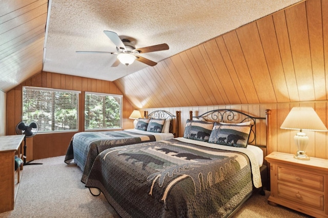 bedroom with wooden walls, ceiling fan, carpet floors, a textured ceiling, and lofted ceiling