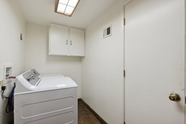 laundry room featuring washing machine and clothes dryer, visible vents, stone finish floor, and cabinet space
