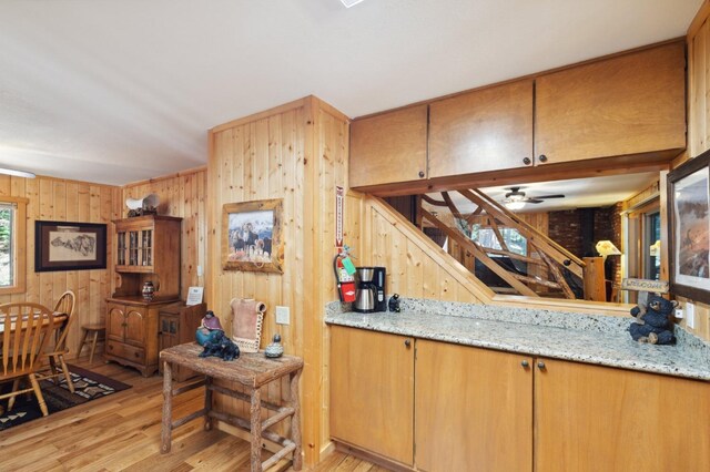 1167 Silver Tip Ln, Fish Camp, CA 93623 - kitchen with light wood finished floors, wood walls, light stone countertops, and a ceiling fan