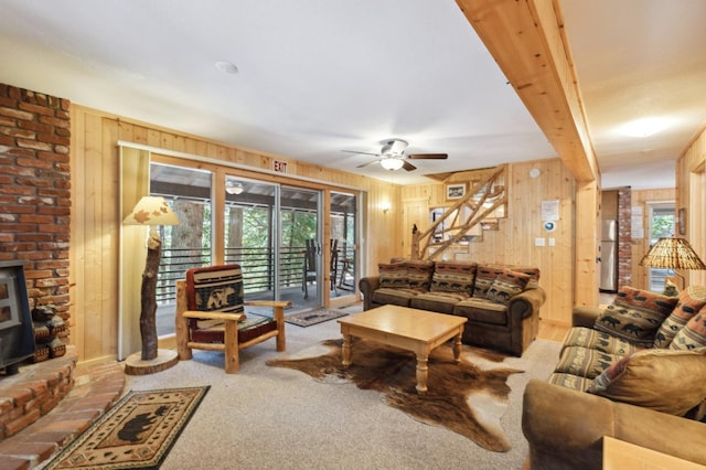 living room featuring wooden walls, plenty of natural light, and a ceiling fan