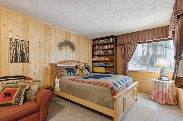 carpeted bedroom with wood walls and a textured ceiling