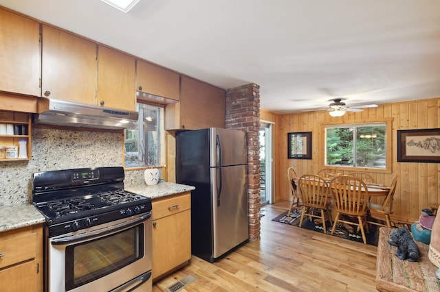 kitchen featuring visible vents, appliances with stainless steel finishes, tasteful backsplash, light wood-style floors, and under cabinet range hood
