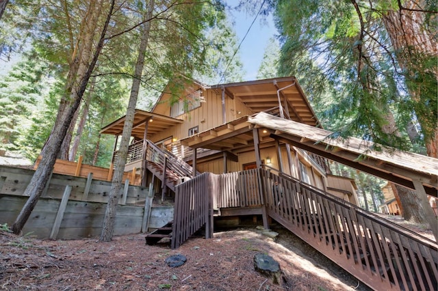 exterior space with a wooden deck, stairs, and board and batten siding