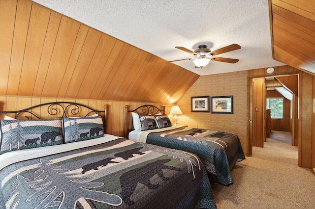 carpeted bedroom featuring wood walls, a textured ceiling, and lofted ceiling
