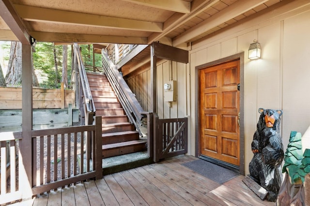 entrance to property with board and batten siding and a deck