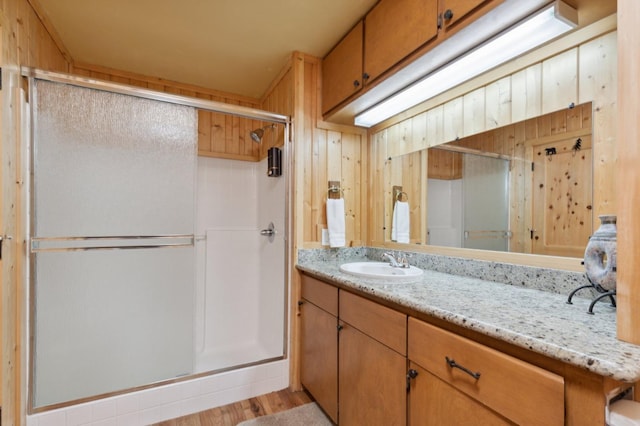 bathroom featuring vanity, a stall shower, and wood finished floors