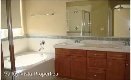 4077 W Peach Tree Ln, Fresno, CA 93722 - full bathroom with a garden tub, double vanity, a sink, and a stall shower