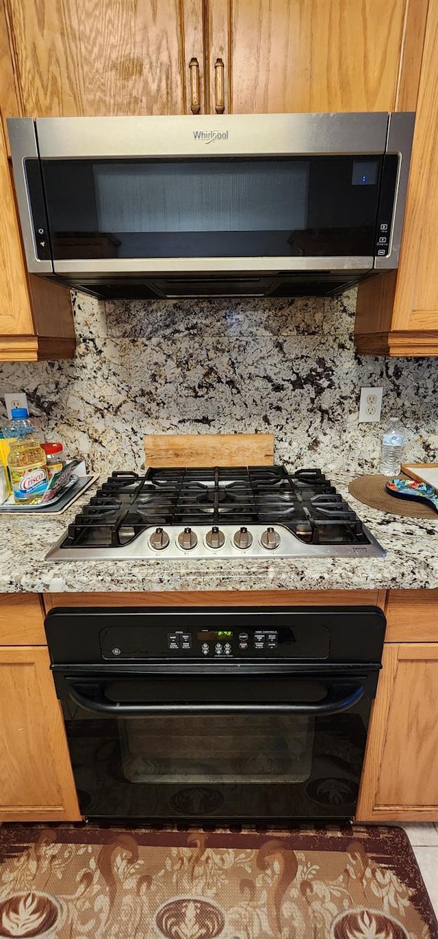 5360 E Heaton Ave, Fresno, CA 93727 - kitchen view of black oven, gas cooktop, backsplash, and light countertops