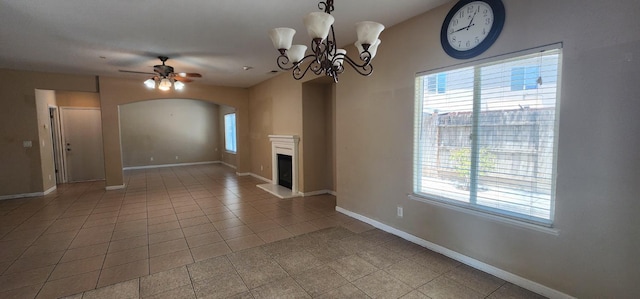 5360 E Heaton Ave, Fresno, CA 93727 - unfurnished living room with arched walkways, healthy amount of natural light, ceiling fan, and a fireplace with raised hearth