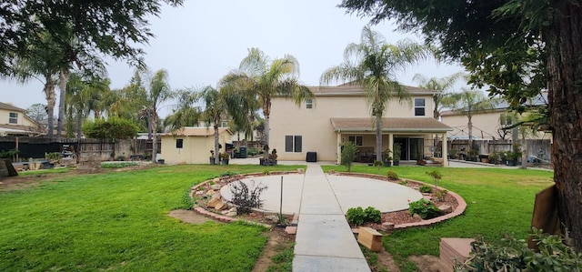 back of house with a lawn, a patio, a fenced backyard, and stucco siding