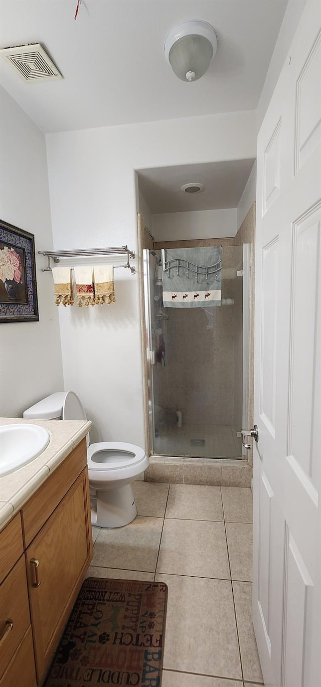 bathroom with visible vents, a shower stall, vanity, tile patterned floors, and toilet