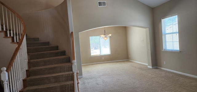 5360 E Heaton Ave, Fresno, CA 93727 - staircase with arched walkways, a chandelier, carpet floors, and baseboards