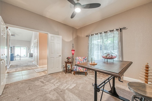 dining space featuring baseboards, carpet flooring, ceiling fan, and tile patterned floors