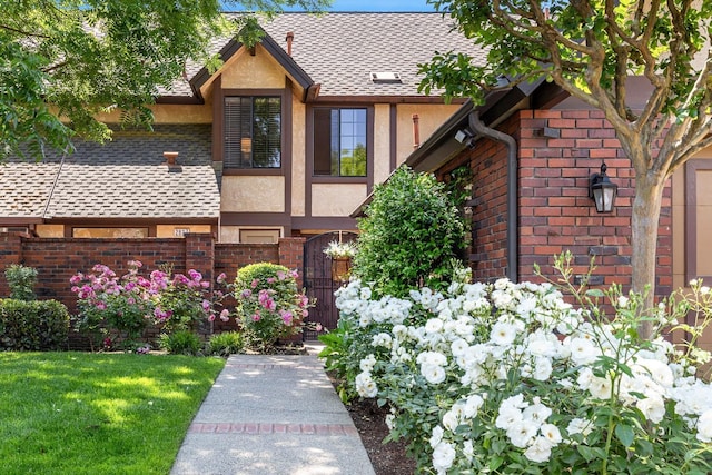 2827 W Compton Ct, Fresno, CA 93711 - tudor-style house with roof with shingles, a gate, brick siding, fence, and stucco siding