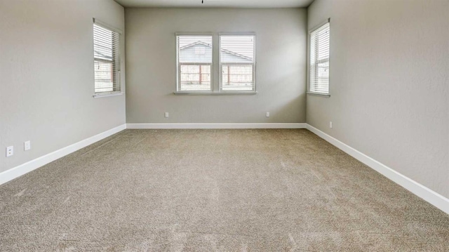 carpeted spare room with baseboards