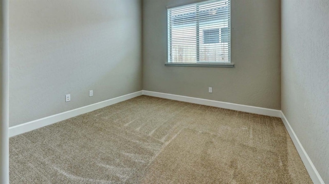 unfurnished room featuring baseboards and carpet flooring
