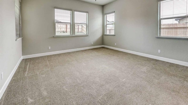 empty room featuring baseboards and carpet flooring