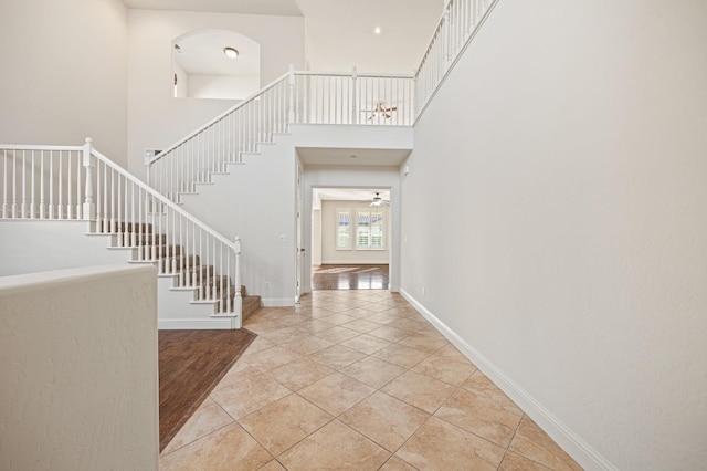 11340 N Via Verona Way, Fresno, CA 93730 - foyer entrance with a ceiling fan, baseboards, light tile patterned floors, a towering ceiling, and stairway