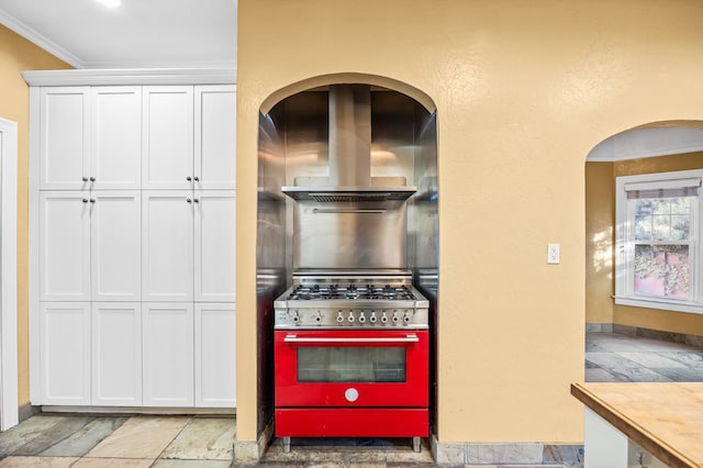 2436 N Van Ness Blvd, Fresno, CA 93704 - kitchen with crown molding, stainless steel stove, extractor fan, stone tile floors, and white cabinetry