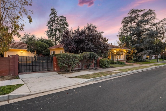 2436 N Van Ness Blvd, Fresno, CA 93704 - view of property hidden behind natural elements featuring a gate, a fenced front yard, and concrete driveway