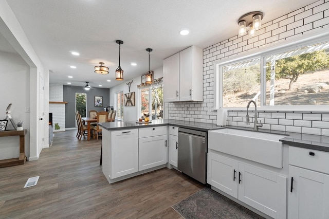 43299 Ranger Circle Dr, Coarsegold, CA 93614 - kitchen with stainless steel dishwasher, visible vents, a peninsula, dark countertops, and a sink
