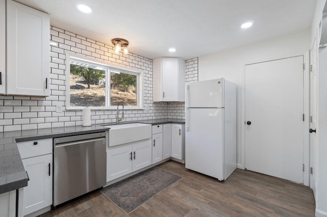43299 Ranger Circle Dr, Coarsegold, CA 93614 - kitchen featuring tasteful backsplash, dishwasher, a sink, freestanding refrigerator, and white cabinetry