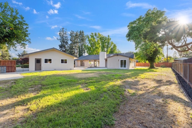 2044 W San Bruno Ave, Fresno, CA 93711 - exterior space featuring a fenced backyard, stucco siding, a chimney, a patio area, and a lawn