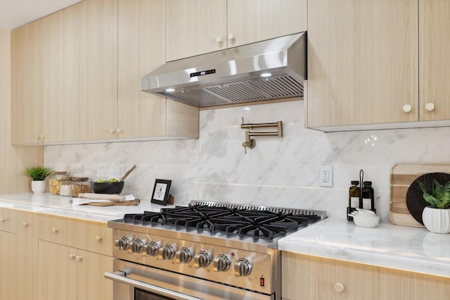 2044 W San Bruno Ave, Fresno, CA 93711 - kitchen featuring under cabinet range hood, tasteful backsplash, high end range, and light countertops