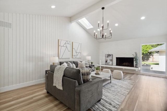 2044 W San Bruno Ave, Fresno, CA 93711 - living area with visible vents, a large fireplace, lofted ceiling with skylight, a notable chandelier, and light wood-style flooring