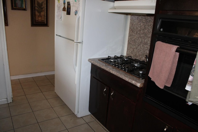 1939 S Sierra Vista Ave, Fresno, CA 93702 - kitchen with light tile patterned floors, black appliances, baseboards, and under cabinet range hood