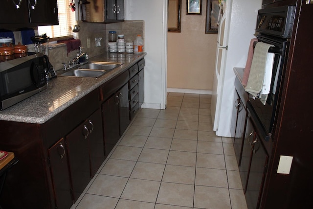 1939 S Sierra Vista Ave, Fresno, CA 93702 - kitchen featuring light tile patterned floors, dark brown cabinets, a sink, stainless steel microwave, and oven