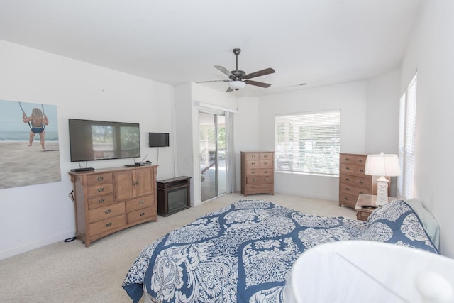 carpeted bedroom featuring baseboards, access to outside, and a ceiling fan