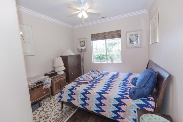 bedroom featuring ceiling fan, ornamental molding, visible vents, and wood finished floors