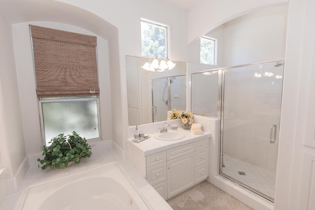 bathroom with a stall shower, a garden tub, and vanity