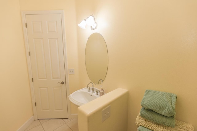 bathroom with tile patterned flooring, baseboards, and a sink