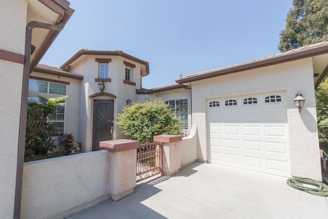 mediterranean / spanish-style house with driveway, stucco siding, and an attached garage