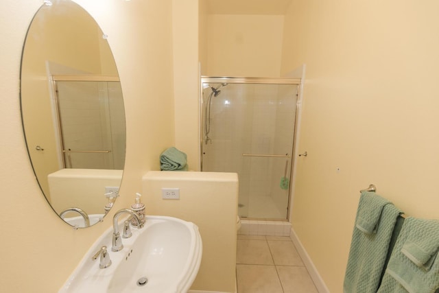 bathroom featuring a sink, a shower stall, and tile patterned floors