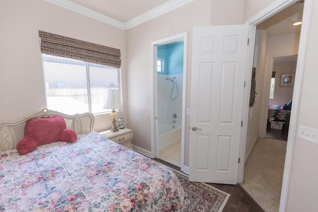 bedroom featuring baseboards, ensuite bathroom, and ornamental molding