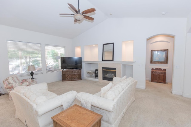 living room with light colored carpet, a fireplace, lofted ceiling, and ceiling fan