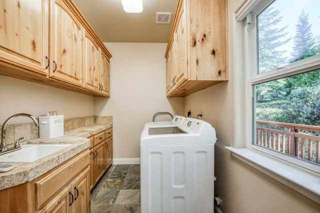 clothes washing area featuring a sink, cabinet space, washing machine and clothes dryer, visible vents, and baseboards