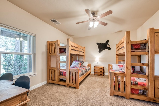 bedroom featuring baseboards, ceiling fan, visible vents, and light colored carpet