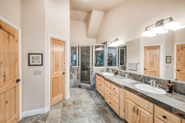 bathroom with a sink, double vanity, baseboards, and a shower stall