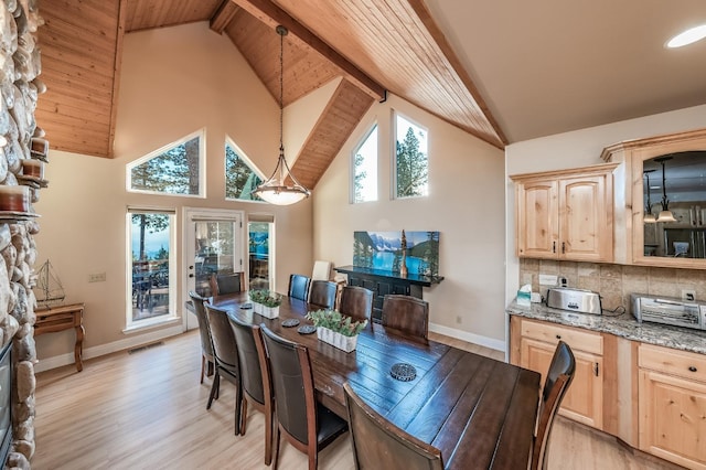 dining space featuring baseboards, light wood-style flooring, beamed ceiling, and high vaulted ceiling