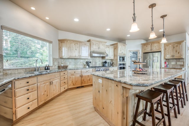 kitchen featuring light wood-type flooring, light brown cabinetry, stainless steel appliances, and decorative backsplash