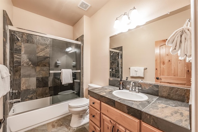 bathroom featuring vanity, toilet, visible vents, and enclosed tub / shower combo