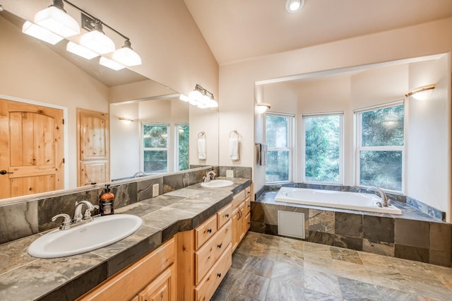 bathroom with double vanity, a bath, high vaulted ceiling, and a sink