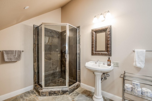 full bath with lofted ceiling, baseboards, and a stall shower