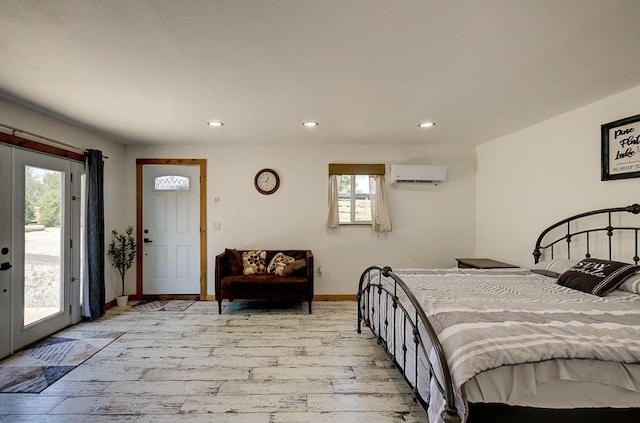 bedroom with light wood-style floors, a wall mounted AC, access to outside, and multiple windows