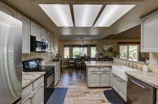 20794 E Weldon Ave, Sanger, CA 93657 - kitchen with appliances with stainless steel finishes, a peninsula, plenty of natural light, and backsplash