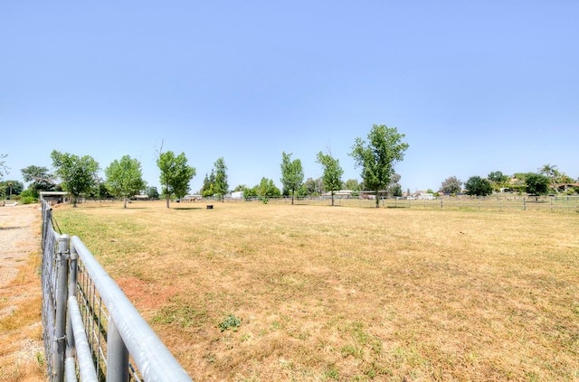 view of yard with a rural view and fence